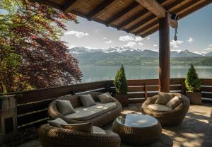 图恩Lakeside Chalet with Panorama View的庭院设有藤椅和桌子,享有湖景