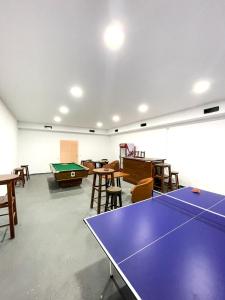 萨兰达Hostel Casa Mia SR的配有乒乓球桌、桌子和椅子的房间