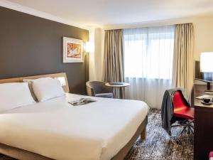 布里斯托诺富特布里斯托尔中心酒店的配有一张床、一张书桌和一扇窗户的酒店客房
