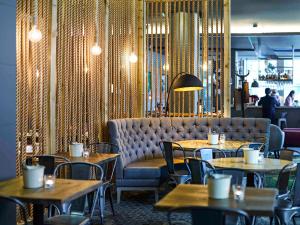 利物浦诺富特利物浦中心酒店的餐厅设有桌椅和沙发。