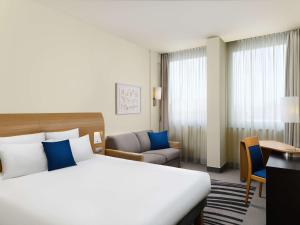 布达佩斯布达佩斯诺富特多瑙河酒店的酒店客房设有一张大床和一张书桌。