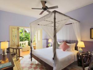 富国La Veranda Resort Phu Quoc - MGallery的一间卧室配有一张带吊扇的床