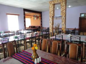 Noorband Qalla Hotel,Bamyan的用餐室配有桌椅和鲜花