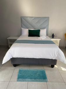 勒斯滕堡Divine Guest Lodge的一间卧室配有一张带绿色枕头的大床