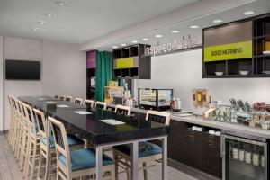 诺克斯维尔Newly Renovated - Home2 Suites by Hilton Knoxville West的餐厅设有大型黑色柜台和椅子