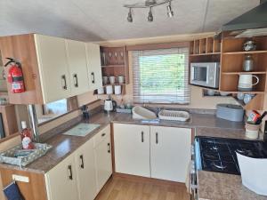 阿贝尔格莱Countryside Caravan Accommodation - Abergele的厨房配有白色橱柜和台面