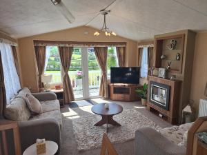 阿贝尔格莱Countryside Caravan Accommodation - Abergele的带沙发和电视的客厅