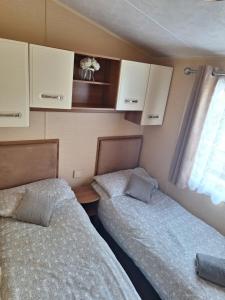 阿贝尔格莱Countryside Caravan Accommodation - Abergele的大篷车小房间内的两张床