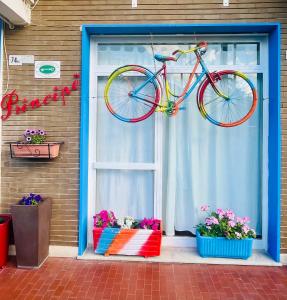 皮特拉利古Hotel Principe的一辆自行车挂在鲜花盛开的窗户上