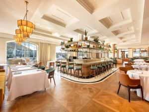 开普敦Cape Grace, A Fairmont Managed Hotel的一间带桌椅的餐厅和一间酒吧