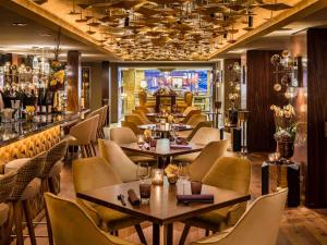 汉堡Fairmont Hotel Vier Jahreszeiten, Hotel des Jahres 2023 & 2024- Die 101 Besten的一间带桌椅的餐厅和一间酒吧