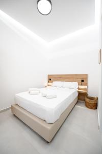 Néa AlikarnassósNBHD STUDIO的一间白色卧室,房间内设有一张大床