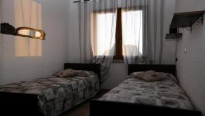 内比达Villetta bordo piscina vista mare Wi-Fi Gratis的带窗户的客房内的两张床