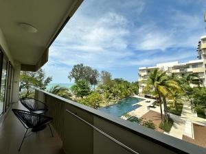 峇都丁宜海滨-泳池海景公寓的享有游泳池和棕榈树景致的阳台