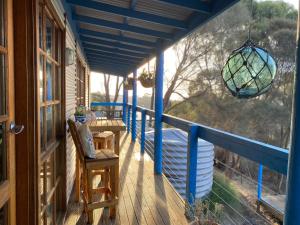 潘尼萧Sheoak Lodge的一个带蓝色栏杆和吊灯的门廊