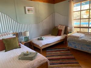 潘尼萧Sheoak Lodge的客房设有两张床和窗户。