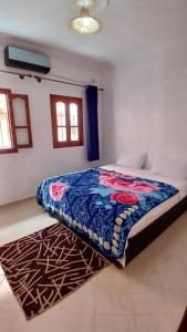 瓦尔扎扎特Warzazat Apartments的一间卧室配有一张带蓝色毯子的床