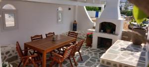 艾丽奇Anixis Studios Aliki Paros的庭院设有木桌、椅子和壁炉。