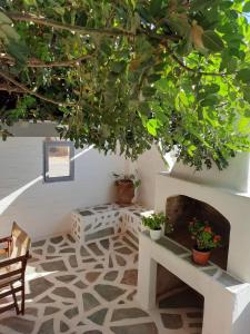 艾丽奇Anixis Studios Aliki Paros的一间带壁炉的客房和一棵种有植物的树