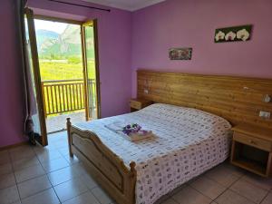 梅佐科罗纳安蒂克菲恩尼尔农庄酒店的一间卧室配有一张紫色墙壁和窗户的床