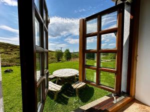泰努尔特Farm Cottage with wood-fired Hot Tub的开放式窗户,配有桌子和野餐桌