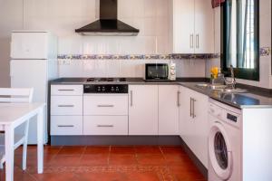 科尼尔-德拉弗龙特拉Casas Rurales Pericón的厨房配有白色橱柜和洗碗机。