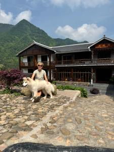 张家界Mountainside的站在一座建筑物前面的两只羊旁边的一个女人