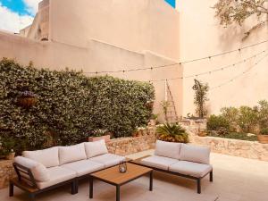 波雷雷斯Atrium Suites Mallorca的庭院配有2张白色沙发和1张桌子