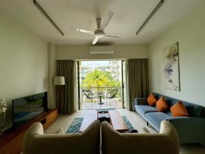 峇都丁宜海滨-泳池海景公寓的客厅配有蓝色的沙发和电视