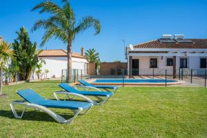 科尼尔-德拉弗龙特拉Casas Rurales Pericón的房子前面草上一排蓝色的躺椅