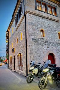 佩奇Hotel - Kulla e Zenel Beut的停在砖楼前的摩托车