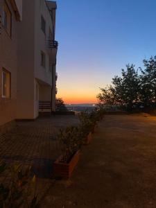 地拉那Sunny Home overlooking Tirana的一座背面有日落的建筑