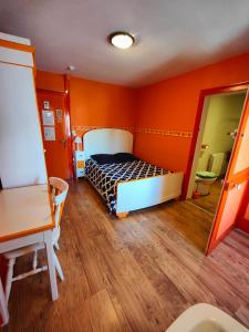 Fresne-Saint-MamèsL'Hôtel du Mouton blanc的一间拥有橙色墙壁的卧室和一张位于客房内的床