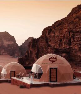 瓦迪拉姆RUM EiLEEN LUXURY CAMP的一群在沙漠中与山 ⁇ 交织的帐篷