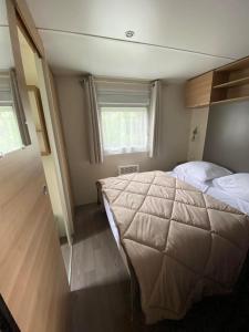 圣康坦昂图尔蒙camping des crocs的一间卧室设有一张大床和两个窗户。