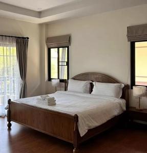 清迈Lanna Art Deer Resort Chiang Mai的一间卧室设有一张大床和两个窗户