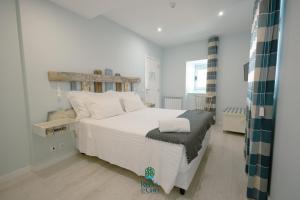 塞亚Casa da Ribeira do Círio的卧室配有白色的床和木制床头板