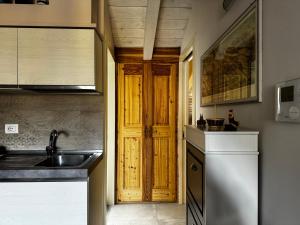 奥斯塔Maison Tatà的一个带水槽和木门的厨房