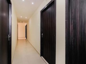噶伦堡OYO Pradhann Home Stay的一条带黑色门的走廊和一条带白色墙壁的走廊