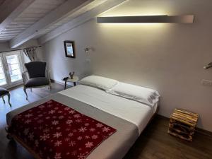 奥斯塔Maison Tatà的一间卧室配有一张床铺,床上铺有红色毯子