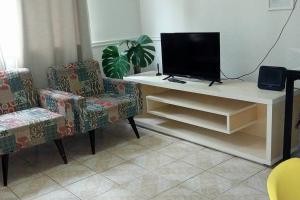 萨尔瓦多Apto Inteiro Stiep的客厅配有电视和2把椅子