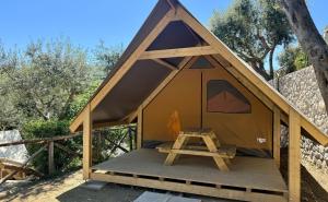 索伦托Hostel & Glamping Santa Fortunata的一个带木门廊的小黄色帐篷