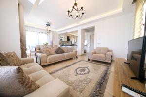费特希耶Turquoise Shores Family-Friendly Luxury Villa Fethiye Oludeniz by Sunworld Villas的客厅配有两张沙发和一台电视机