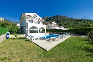 费特希耶Turquoise Shores Family-Friendly Luxury Villa Fethiye Oludeniz by Sunworld Villas的庭院中带游泳池的房子