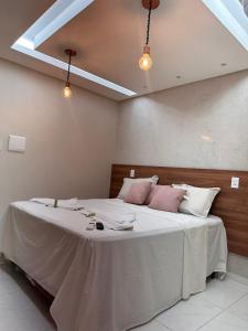 马塞约Pousada Beija Flor的卧室配有一张带白色粉色枕头的大床