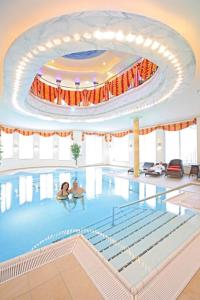 巴登韦勒后温泉健康私人酒店的一座大型游泳池,其中有2人