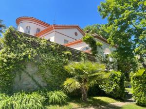 奥洛特Espectacular Casa Chateau en el centro de Olot的前面有棕榈树的建筑