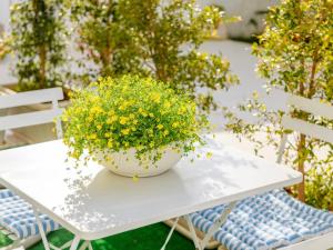 切萨雷奥港Ideal Rooms的一张白色桌子,上面放着一碗黄色的鲜花