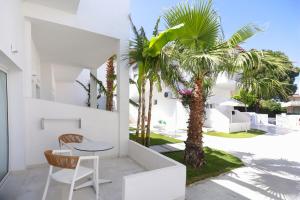 卡尼奥提Lefko Suites的白色的房子,配有桌子和棕榈树