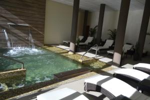 科隆普拉塞酒店的一座建筑中间的游泳池,有一个喷泉